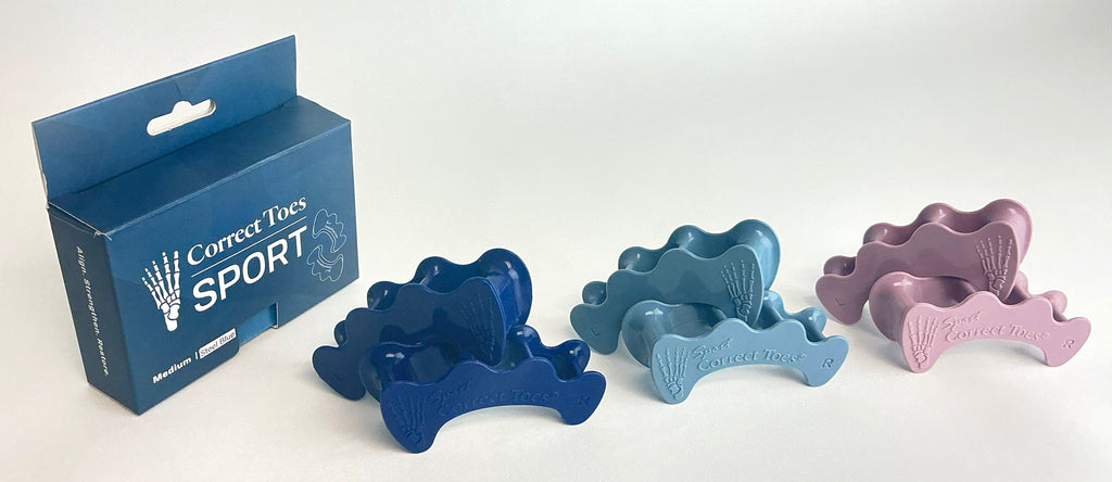 Set of four Correct Toes SPORT® toe spacers in dark blue, light blue, and mauve next to blue product box.