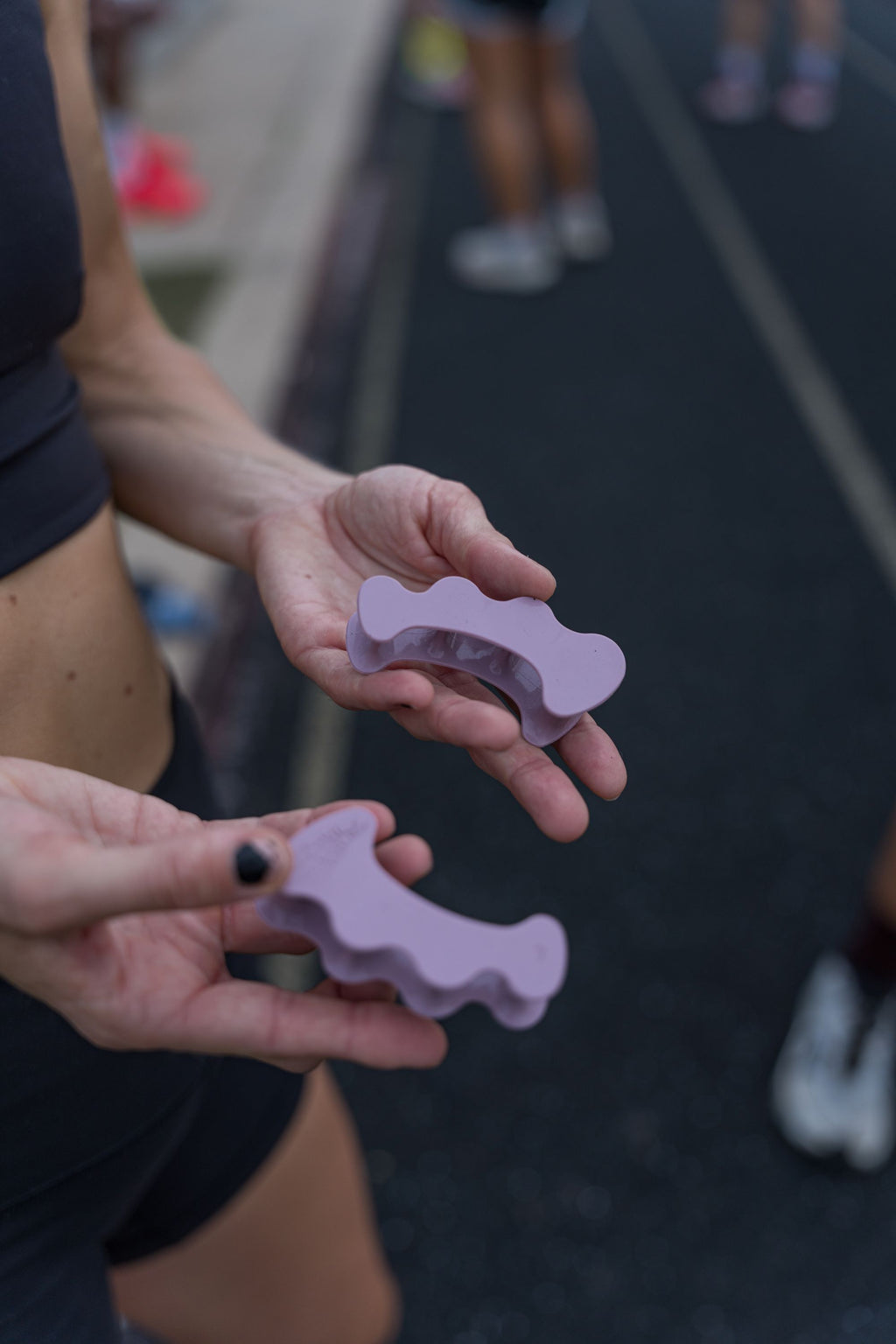 Pair of mauve silicone toe spacers designed with rounded edges for athletic use.
